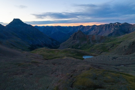 Aerial view of Mount Sneffels and the rugged San Juan Mountains in the Rocky Mountains at dawn with an alpine lake in Yankee Boy Basin Ouray County Colorado United States. Aerial view of Mount Sneffels and the rugged San Juan Mountains in the Rocky Mountains at dawn with an alpine lake in Yankee Boy Basin Ouray County Colorado United States.