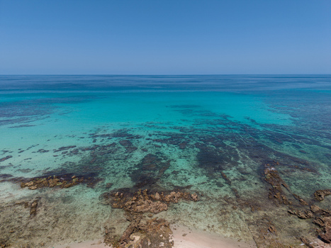 Aerial view of the turquoise waters meeting the rugged coastline a dance of contrasting colors under the vast blue sky Siqirah Socotra Yemen. Aerial view of the turquoise waters meeting the rugged coastline a dance of contrasting colors under the vast blue sky Siqirah Socotra Yemen.