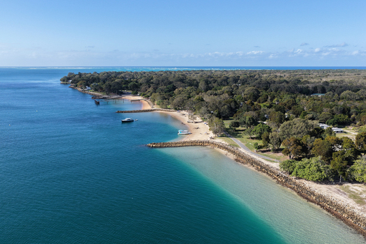 Aerial view of the coastline at Amity Point on Minjerribah North Stradbroke Island featuring sandy beaches rocky groynes and the turquoise waters of Moreton Bay Amity Point Queensland Australia. Aerial view of the coastline at Amity Point on Minjerribah North Stradbroke Island featuring sandy beaches rocky groynes and the turquoise waters of Moreton Bay Amity Point Queensland Australia.