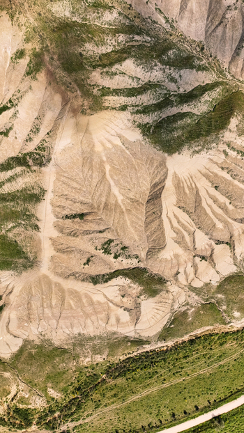 Aerial view of the rugged earthy landscape is etched with deep ravines and sparse vegetation a tapestry of beige and green textures Centuripe Sicilia Italy. Aerial view of the rugged earthy landscape is etched with deep ravines and sparse vegetation a tapestry of beige and green textures Centuripe Sicilia Italy.