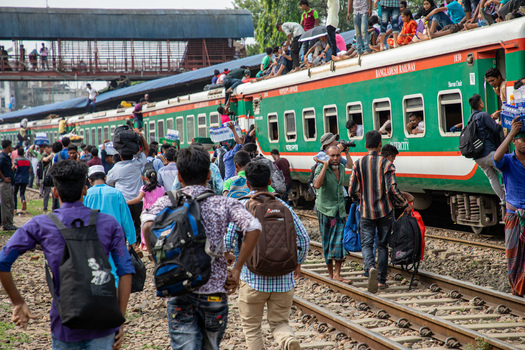 Dhaka Bangladesh 14 June 2018 View of Airport Railway Station crowded with passengers boarding trains and sitting on rooftops during the Eid al Fitr holiday rush. Dhaka Bangladesh 14 June 2018 View of Airport Railway Station crowded with passengers boarding trains and sitting on rooftops during the Eid al Fitr holiday rush.