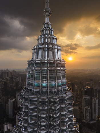 Kuala Lumpur Malaysia 11 March 2026 Aerial view of the Petronas Twin Towers at sunset with dramatic clouds and the city skyline in the background.