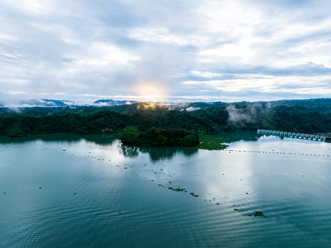 Aerial view of the serene Kaptai Lake surrounded by lush green hills under a dramatic cloudy sky at sunset in Rangamati Chittagong Division Bangladesh. Aerial view of the serene Kaptai Lake surrounded by lush green hills under a dramatic cloudy sky at sunset in Rangamati Chittagong Division Bangladesh.