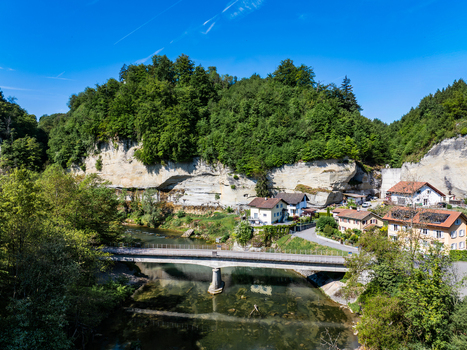 Aerial view of the Pont de la Motta bridge spanning the Sarine river with rocky cliffs lush green forests and traditional houses Fribourg Fribourg Switzerland. Aerial view of the Pont de la Motta bridge spanning the Sarine river with rocky cliffs lush green forests and traditional houses Fribourg Fribourg Switzerland.