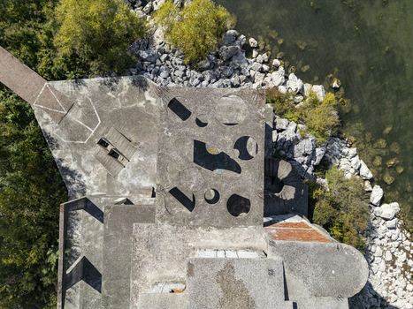Aerial view of the concrete structure with geometric cutouts and a spiral staircase on the rocky shore of Lake Shkoder Shiroka Shkoder County Albania. Aerial view of the concrete structure with geometric cutouts and a spiral staircase on the rocky shore of Lake Shkoder Shiroka Shkoder County Albania.