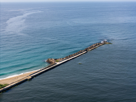 Aerial view of the breakwater at the mouth of the Rio Ozama extending into the Caribbean Sea with concrete tetrapods and calm blue water in Santo Domingo Santo Domingo Dominican Republic.