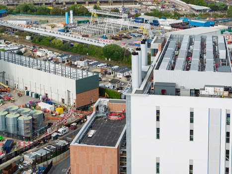 Aerial view of a large data center construction site featuring industrial chimneys storage tanks and heavy machinery in the United Kingdom. Aerial view of a large data center construction site featuring industrial chimneys storage tanks and heavy machinery in the United Kingdom.