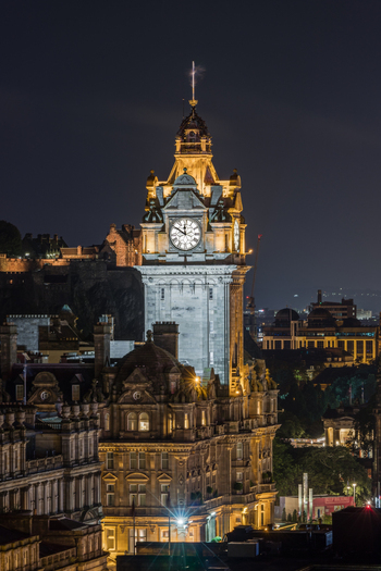 View of the illuminated Balmoral Hotel clock tower and Edinburgh Castle at night Edinburgh Scotland United Kingdom. View of the illuminated Balmoral Hotel clock tower and Edinburgh Castle at night Edinburgh Scotland United Kingdom.