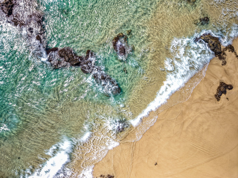 Aerial view of Cudgen Headland South Head with turquoise ocean waves crashing against dark volcanic rocks and golden sand in Kingscliff New South Wales Australia. Aerial view of Cudgen Headland South Head with turquoise ocean waves crashing against dark volcanic rocks and golden sand in Kingscliff New South Wales Australia.