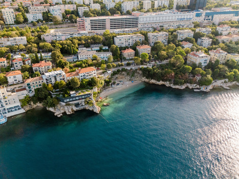 Aerial view of the coastal area showing the beach rocky cliffs residential buildings and the Tower Center in the background. Rijeka Primorje Gorski Kotar Croatia.