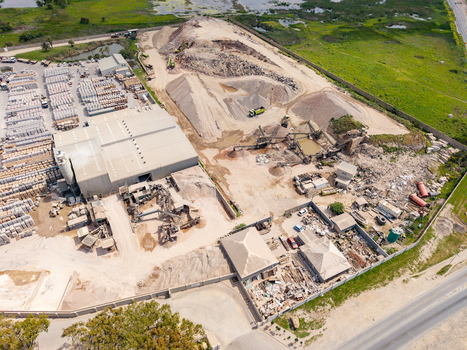 Aerial view of the industrial site in Philippi with piles of sand and gravel heavy machinery and storage facilities in Cape Town Western Cape South Africa.