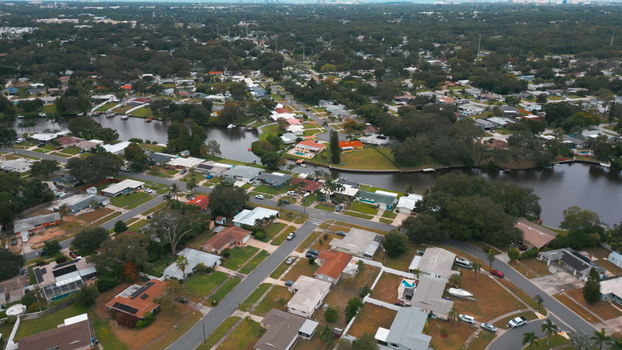 Aerial view of a residential neighborhood with houses winding canals and lush trees in Clearwater Florida United States. Aerial view of a residential neighborhood with houses winding canals and lush trees in Clearwater Florida United States.