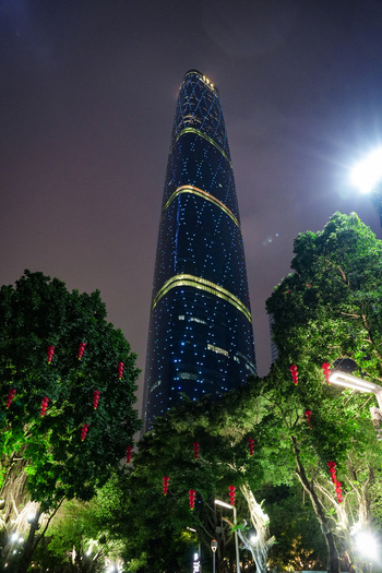 Guangzhou China 24 February 2024 View of the illuminated Guangzhou International Finance Center skyscraper at night surrounded by trees decorated with traditional red lanterns. Guangzhou China 24 February 2024 View of the illuminated Guangzhou International Finance Center skyscraper at night surrounded by trees decorated with traditional red lanterns.