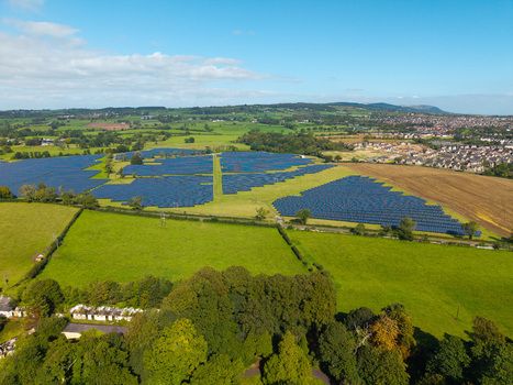 Aerial view of a large solar farm situated in a rural landscape with green fields and trees near Lisburn Northern Ireland United Kingdom. Aerial view of a large solar farm situated in a rural landscape with green fields and trees near Lisburn Northern Ireland United Kingdom.