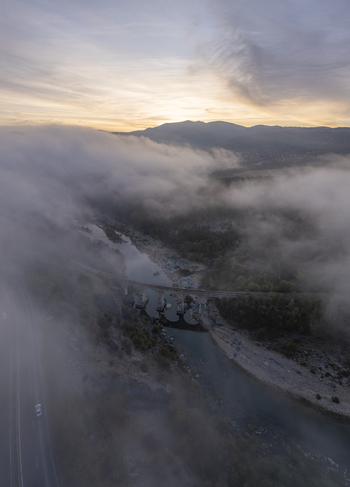 Aerial view of the historic railway bridge spanning a river amidst dense morning fog and rolling mountains during golden hour in Balabanovo Kardzhali Province Bulgaria. Aerial view of the historic railway bridge spanning a river amidst dense morning fog and rolling mountains during golden hour in Balabanovo Kardzhali Province Bulgaria.