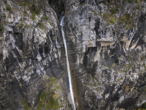 Aerial view of a waterfall cascading down a steep rocky cliff face in the Pyrenees mountains Spain. Aerial view of a waterfall cascading down a steep rocky cliff face in the Pyrenees mountains Spain.