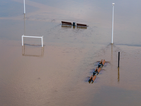 Aerial view of a flooded park with submerged benches a soccer goal and lamp posts in murky water in Kedainiai Kaunas County Lithuania. Aerial view of a flooded park with submerged benches a soccer goal and lamp posts in murky water in Kedainiai Kaunas County Lithuania.