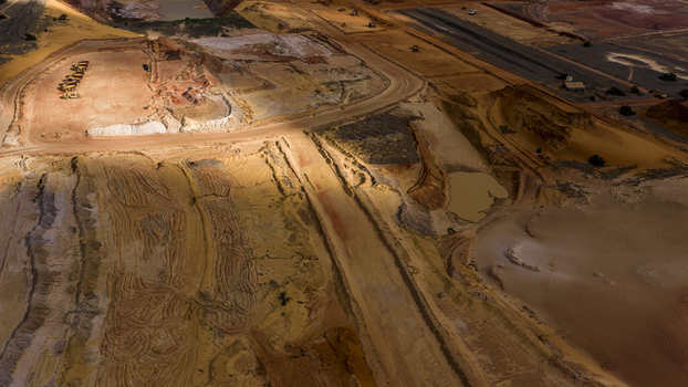Aerial view of an industrial mining site with distinct earthwork patterns sand and heavy machinery in the arid landscape of Kalbarri Western Australia Australia. Aerial view of an industrial mining site with distinct earthwork patterns sand and heavy machinery in the arid landscape of Kalbarri Western Australia Australia.