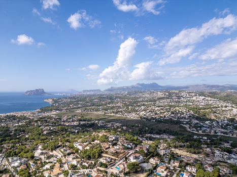 Aerial view of the coastal town of Moraira with its residential areas lush greenery and Mediterranean coastline in Moraira Valencian Community Spain.