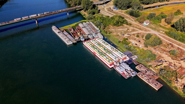 Aerial view of Smederevo bridge and shipyard with multiple cargo barges docked along the riverbank in Smederevo Podunavlje District Serbia.