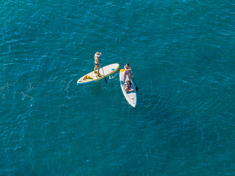 Aerial view of people paddleboarding on clear blue sea water in Antibes Provence Alpes Cote d Azur France. Aerial view of people paddleboarding on clear blue sea water in Antibes Provence Alpes Cote d Azur France.