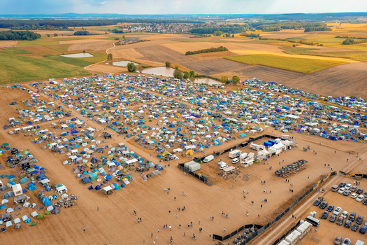 Aerial view of the Open Beatz Festival campsite with colorful tents and people walking near agricultural fields in Herzogenaurach Bayern Germany. Aerial view of the Open Beatz Festival campsite with colorful tents and people walking near agricultural fields in Herzogenaurach Bayern Germany.