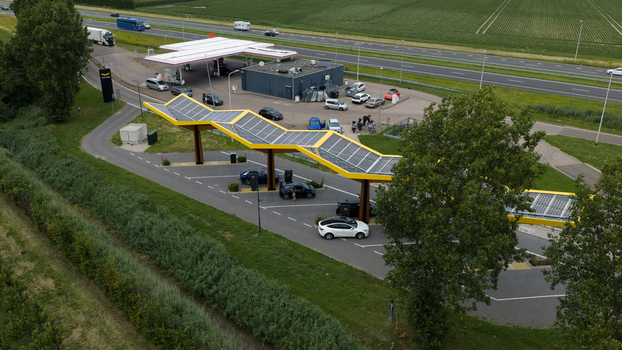 Krabbendijke Netherlands 28 June 2026 Aerial view of the Fastned charging station with solar panel roof electric vehicles charging and the adjacent highway in the rural landscape. Krabbendijke Netherlands 28 June 2026 Aerial view of the Fastned charging station with solar panel roof electric vehicles charging and the adjacent highway in the rural landscape.