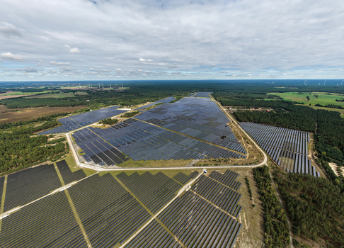 Aerial view of the former Military Airfield Preschen now a large scale solar farm with rows of photovoltaic panels and historic hangars in Neisse Malxetal Brandenburg Germany. Aerial view of the former Military Airfield Preschen now a large scale solar farm with rows of photovoltaic panels and historic hangars in Neisse Malxetal Brandenburg Germany.