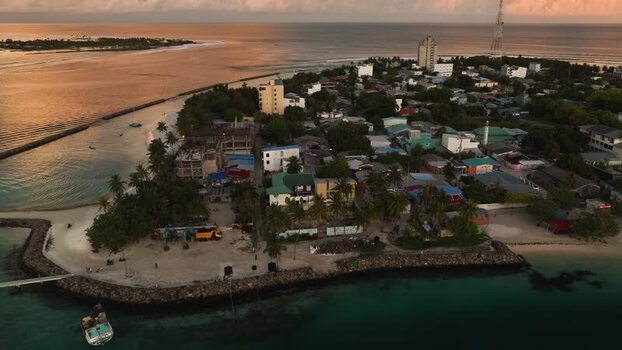 Aerial view of the coastal town and harbor at sunset in Maldives. Aerial view of the coastal town and harbor at sunset in Maldives.