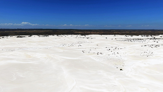 Aerial view of the vast white Lancelin Sand Dunes under a clear blue sky in Lancelin Western Australia Australia. Aerial view of the vast white Lancelin Sand Dunes under a clear blue sky in Lancelin Western Australia Australia.