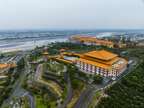 Aerial view of the Fo Guang Shan Buddha Museum with its distinctive orange tiled roofs expansive courtyards and surrounding lush greenery in Jiuru Township Pingtung County Taiwan. Aerial view of the Fo Guang Shan Buddha Museum with its distinctive orange tiled roofs expansive courtyards and surrounding lush greenery in Jiuru Township Pingtung County Taiwan.