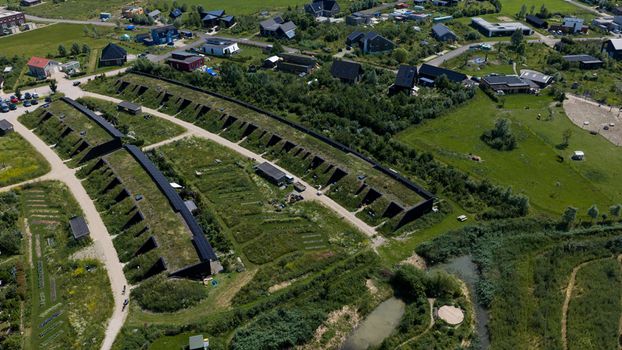 Aerial view of earth sheltered grass roofed modern houses arranged in rows within a green residential area in Almere Flevoland Netherlands. Aerial view of earth sheltered grass roofed modern houses arranged in rows within a green residential area in Almere Flevoland Netherlands.