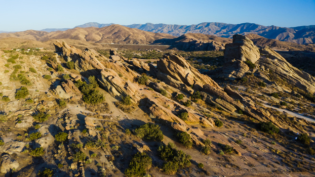 Aerial view of the jagged rock formations at Vasquez Rocks Natural Area Park with dry desert vegetation and golden hour light in the United States. Aerial view of the jagged rock formations at Vasquez Rocks Natural Area Park with dry desert vegetation and golden hour light in the United States.