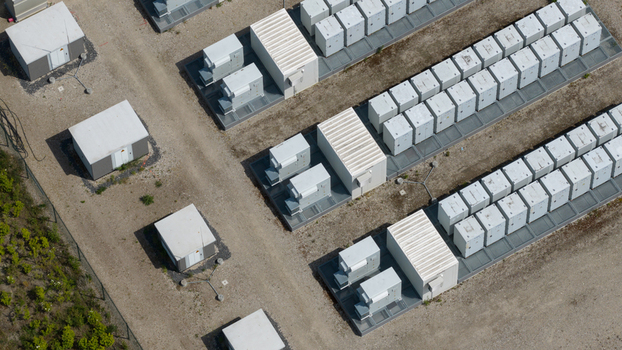 Aerial view of a battery energy storage system facility with rows of white battery containers and electrical equipment on a gravel site in Wanneperveen Overijssel Netherlands.