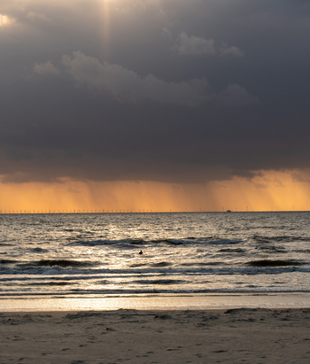 View of Strand Wijk aan Zee with waves crashing on the shore of the North Sea under dramatic storm clouds and golden sunset light Wijk aan Zee North Holland Netherlands. View of Strand Wijk aan Zee with waves crashing on the shore of the North Sea under dramatic storm clouds and golden sunset light Wijk aan Zee North Holland Netherlands.