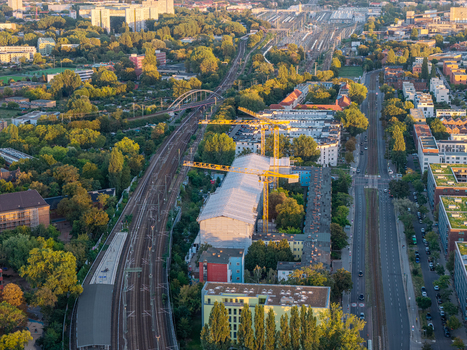 Aerial view of Schlichtallee new residential complex site with yellow construction cranes surrounding apartment buildings railway tracks and urban greenery in Berlin Berlin Germany. Aerial view of Schlichtallee new residential complex site with yellow construction cranes surrounding apartment buildings railway tracks and urban greenery in Berlin Berlin Germany.