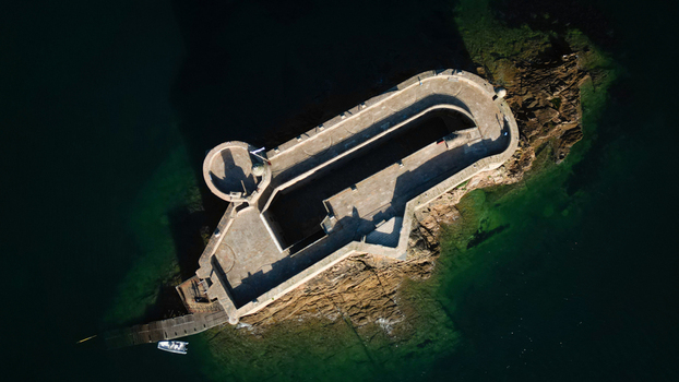 Aerial view of the ancient Chateau du Taureau fortress its rugged stone walls contrasting with the deep emerald waters surrounding its rocky island Plouezoc h Bretagne France. Aerial view of the ancient Chateau du Taureau fortress its rugged stone walls contrasting with the deep emerald waters surrounding its rocky island Plouezoc h Bretagne France.