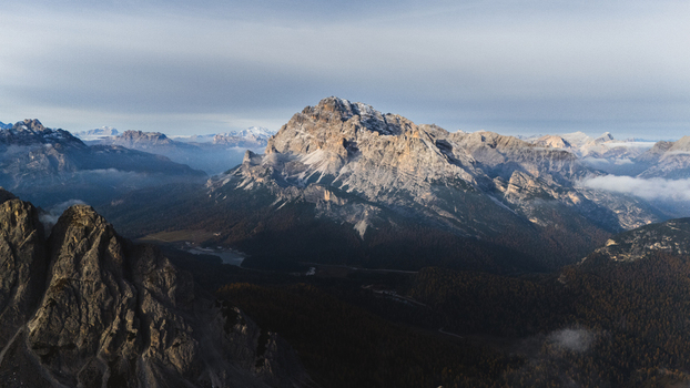 Aerial view of the Monte Cristallo rugged peaks and rock formations above misty valleys in the Dolomites Tre Cime di Lavaredo Veneto Italy. Aerial view of the Monte Cristallo rugged peaks and rock formations above misty valleys in the Dolomites Tre Cime di Lavaredo Veneto Italy.