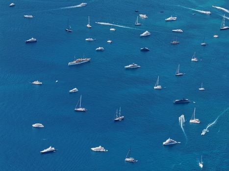 Aerial view of numerous luxury yachts and sailboats anchored in the deep blue waters surrounding the Ile Sainte Marguerite near Cannes Provence Alpes Cote d Azur France. Aerial view of numerous luxury yachts and sailboats anchored in the deep blue waters surrounding the Ile Sainte Marguerite near Cannes Provence Alpes Cote d Azur France.