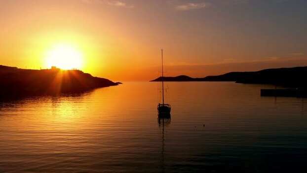 Aerial view of a sailboat in a calm bay at sunset Greece. Aerial view of a sailboat in a calm bay at sunset Greece.