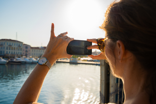 Venice Italy 29 March 2026 View of a woman capturing a photo of the canal s glimmering waters and historic buildings under the bright warm sunlight. Venice Italy 29 March 2026 View of a woman capturing a photo of the canal s glimmering waters and historic buildings under the bright warm sunlight.