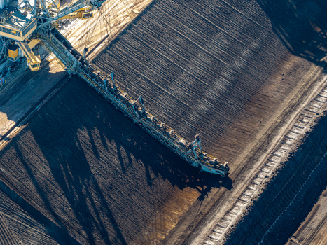 Aerial view of the Tagebau Welzow Sud brown coal open pit mine featuring a massive bucket wheel excavator extracting earth in Spremberg Brandenburg Germany. Aerial view of the Tagebau Welzow Sud brown coal open pit mine featuring a massive bucket wheel excavator extracting earth in Spremberg Brandenburg Germany.