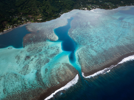 Aerial view of the turquoise lagoon and coral reef with waves breaking at the reef pass along the lush tropical coastline of Moorea Maiao Windward Islands French Polynesia. Aerial view of the turquoise lagoon and coral reef with waves breaking at the reef pass along the lush tropical coastline of Moorea Maiao Windward Islands French Polynesia.