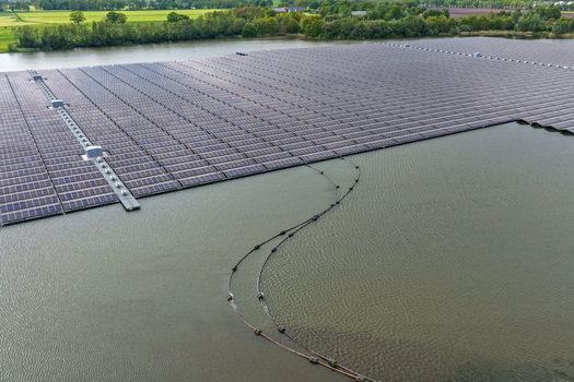 Aerial view of a large scale floating solar farm installed on a calm lake surface near green forests in Beilen Drenthe Netherlands. Aerial view of a large scale floating solar farm installed on a calm lake surface near green forests in Beilen Drenthe Netherlands.