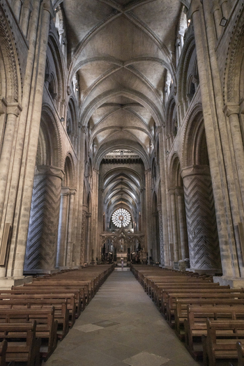 View of the interior of Durham Cathedral with its iconic Norman architecture ribbed vaulted ceilings and rows of wooden pews in Durham England United Kingdom. View of the interior of Durham Cathedral with its iconic Norman architecture ribbed vaulted ceilings and rows of wooden pews in Durham England United Kingdom.
