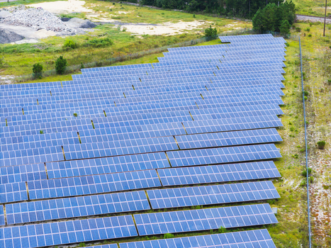 Aerial view of a large solar farm with rows of photovoltaic panels installed in a grassy field in Wilmington North Carolina United States. Aerial view of a large solar farm with rows of photovoltaic panels installed in a grassy field in Wilmington North Carolina United States.