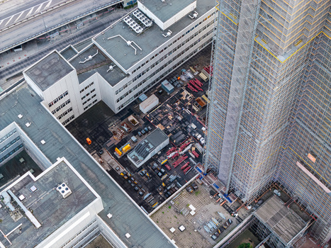 Aerial view of Steglitzer Kreisel with construction scaffolding on the high rise tower and surrounding flat roofed office buildings in Berlin Berlin Germany. Aerial view of Steglitzer Kreisel with construction scaffolding on the high rise tower and surrounding flat roofed office buildings in Berlin Berlin Germany.