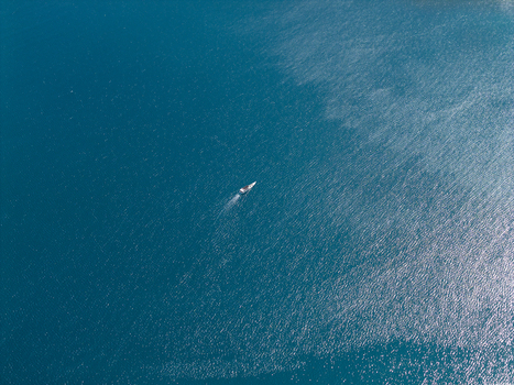 Aerial view of a lone boat cutting through the turquoise waters leaving a white wake behind Karimunjawa Central Java Indonesia.