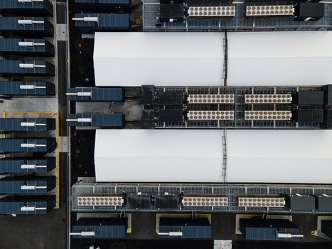 Aerial view of a modern data center facility featuring rows of server containers and industrial cooling units arranged in a structured layout in Keflavik Reykjanesbaer Iceland. Aerial view of a modern data center facility featuring rows of server containers and industrial cooling units arranged in a structured layout in Keflavik Reykjanesbaer Iceland.