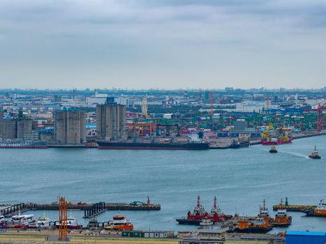 Aerial view of the busy industrial port of Taichung with large cargo ships industrial silos and tugboats navigating the calm waters under a cloudy sky in Taichung Taichung City Taiwan. Aerial view of the busy industrial port of Taichung with large cargo ships industrial silos and tugboats navigating the calm waters under a cloudy sky in Taichung Taichung City Taiwan.